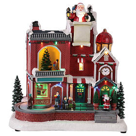 Maison rouge du Père Noël animée par des LEDs et musique 30x20x35 cm