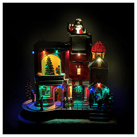 Maison rouge du Père Noël animée par des LEDs et musique 30x20x35 cm