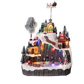 Montagna con pista di pattinaggio e slitta animata luci e musica 30x20x30 cm