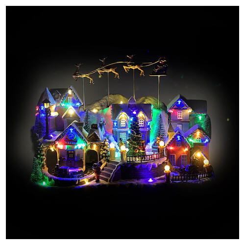 Villaggio di Natale con renne e Babbo Natale volanti animati luci e musica 40x25x30 cm 2