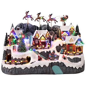 Mountain Christmas village with stream and animated skaters lights and music 60x35x40 cm