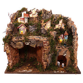 Illuminated village on mountain with cave and hayloft Nativity scene 9 cm