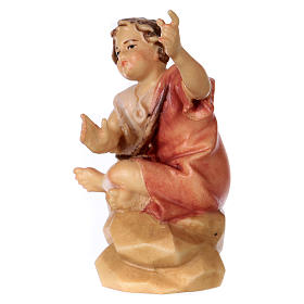 Enfant assis sur rocher pour crèche Original Berger bois peint Val Gardena 10 cm