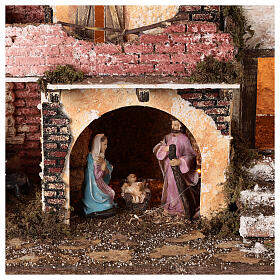 Aldeia com pórtico e muros de tijolos, luzes e fogo, Natividade figuras altura média 10 cm; medidas: 38x45x30 cm