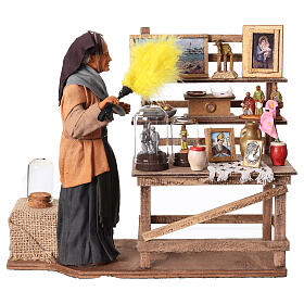 Femme âgée dépoussiérant une étagère mouvement crèche napolitaine 30 cm